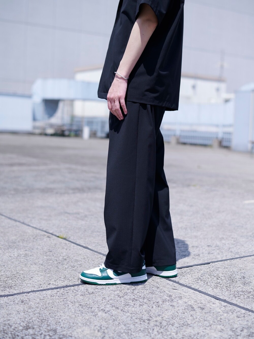 ブラック系のスラックスを着用したメンズの春コーディネートの4枚目の写真