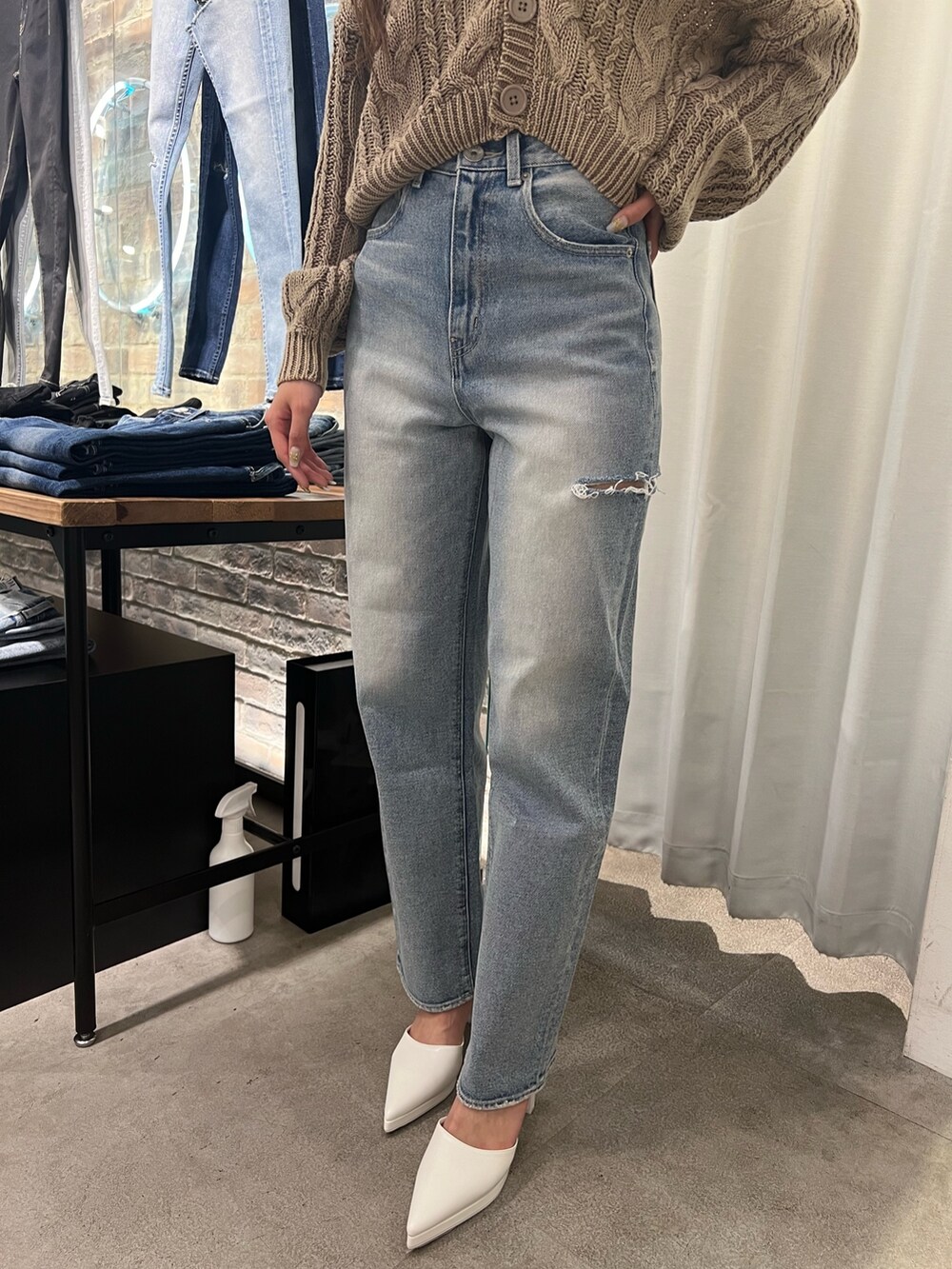 ブルー系のニット/セーター、ホワイト系のキャミソール、ブルー系のデニムパンツを着用したレディースの冬コーディネートの4枚目の写真