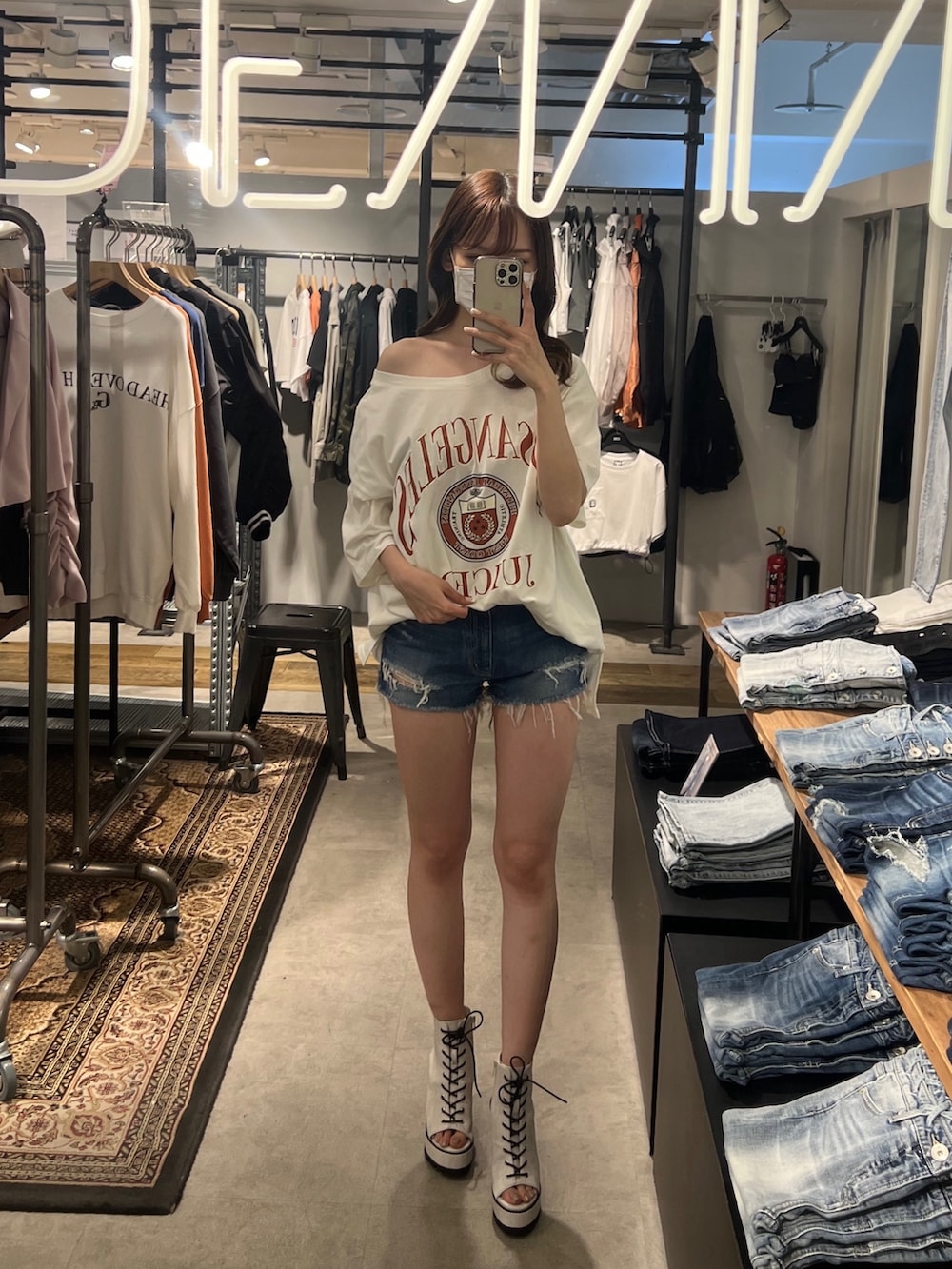 ホワイト系のブーツ、ホワイト系のTシャツ/カットソー、ブルー系のデニムパンツを着用したレディースの春コーディネートの2枚目の写真