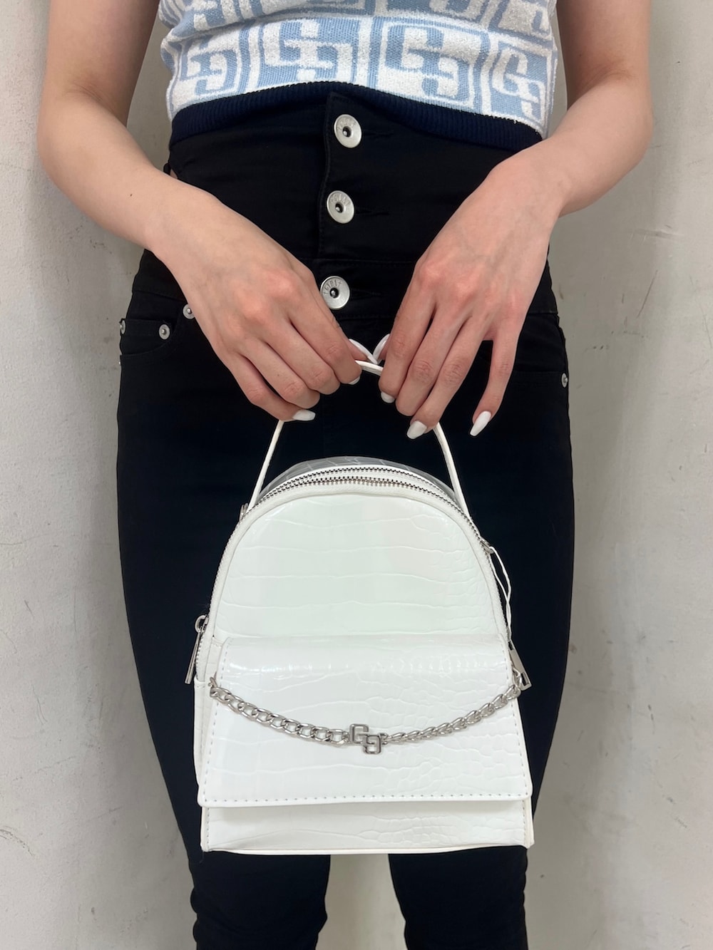 ブルー系のニット/セーター、ホワイト系のバックパック/リュック、ブラック系のパンプスを着用したレディースの春コーディネートの6枚目の写真