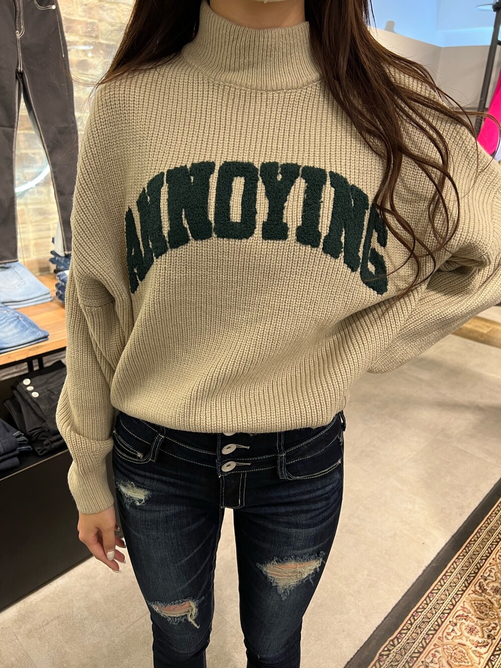 ベージュ系のニット/セーター、ブルー系のデニムパンツ、ブラック系のパンプスを着用したレディースの冬コーディネートの3枚目の写真