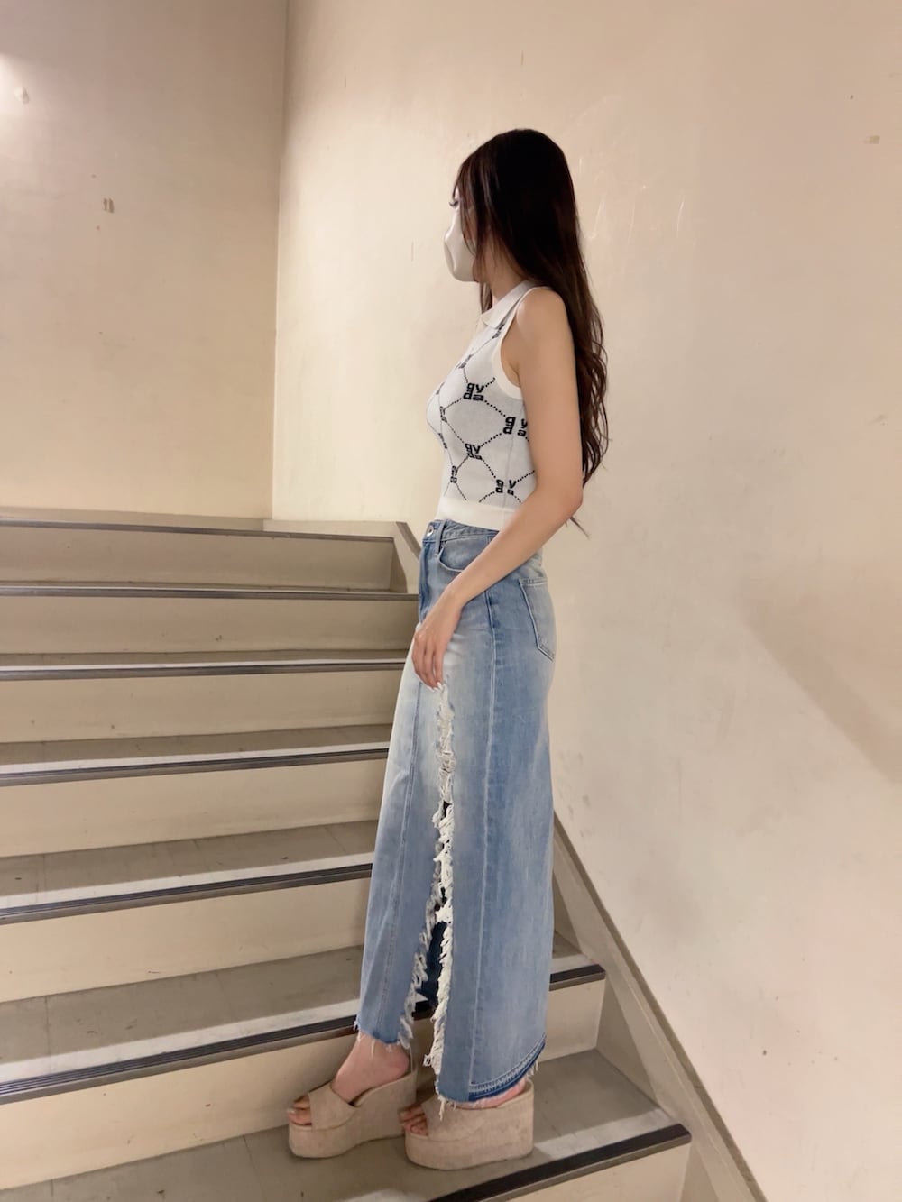 ホワイト系のニット/セーター、ブルー系のデニムスカート、ホワイト系のサンダルを着用したレディースの春コーディネートの3枚目の写真