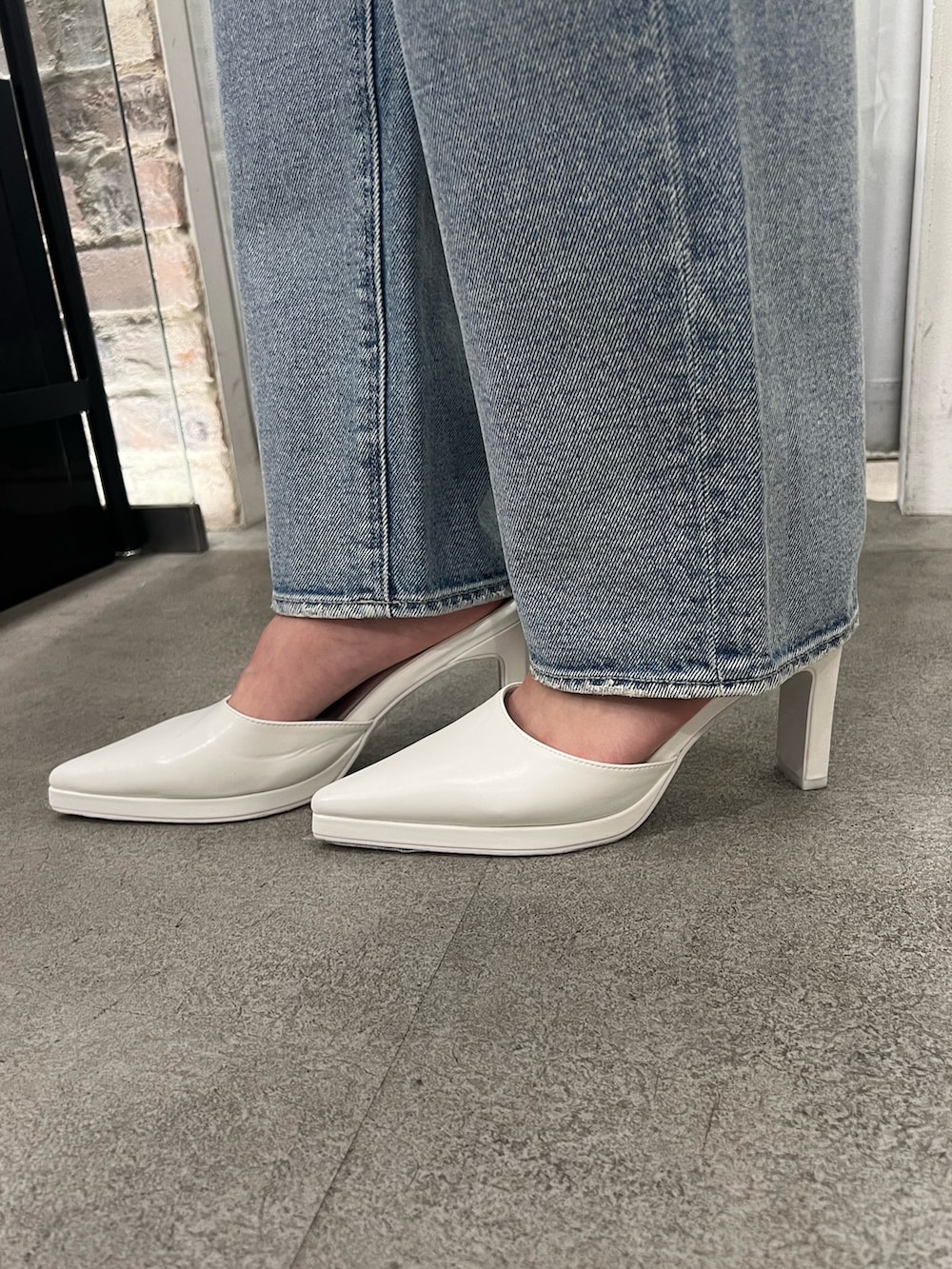 ブルー系のニット/セーター、ホワイト系のキャミソール、ブルー系のデニムパンツを着用したレディースの冬コーディネートの5枚目の写真