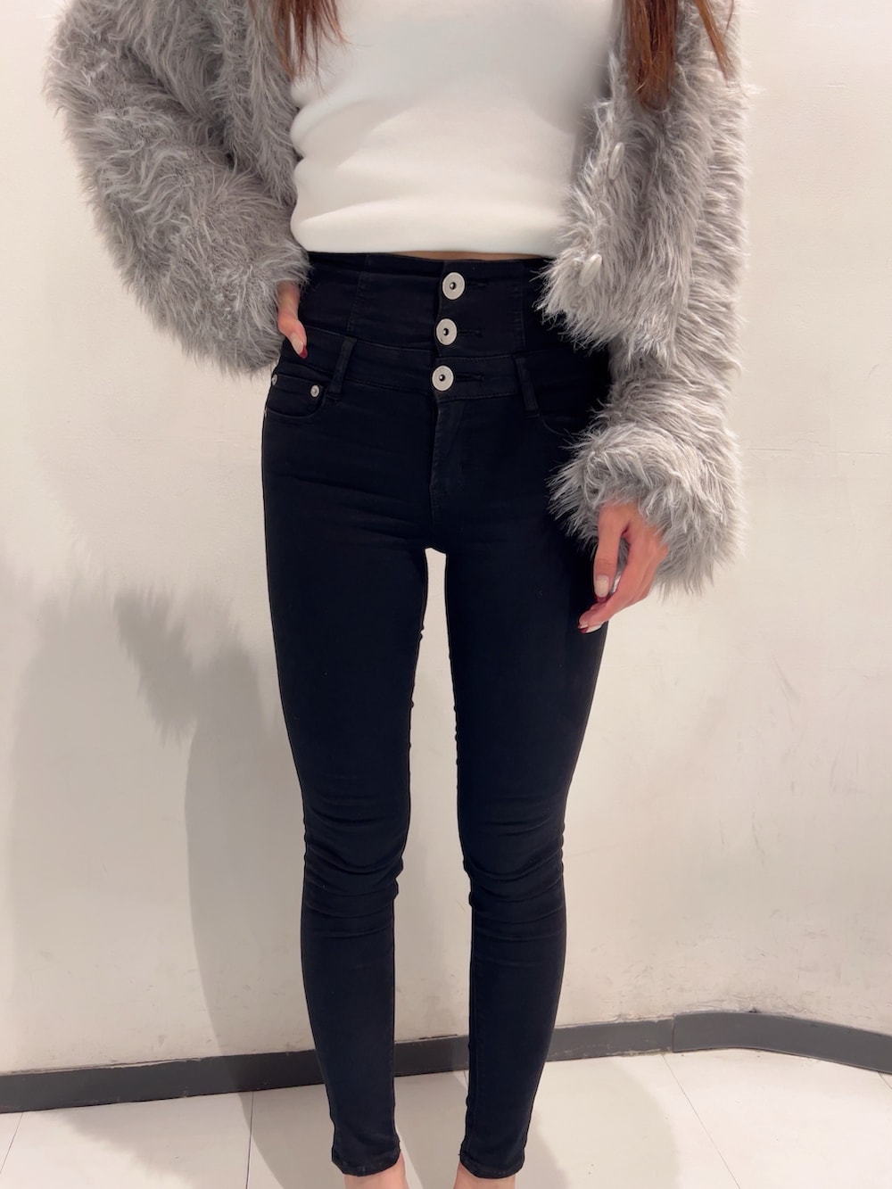 グレー系のカーディガン/ボレロ、ホワイト系のキャミソール、ブラック系のデニムパンツを着用したレディースの秋コーディネートの5枚目の写真