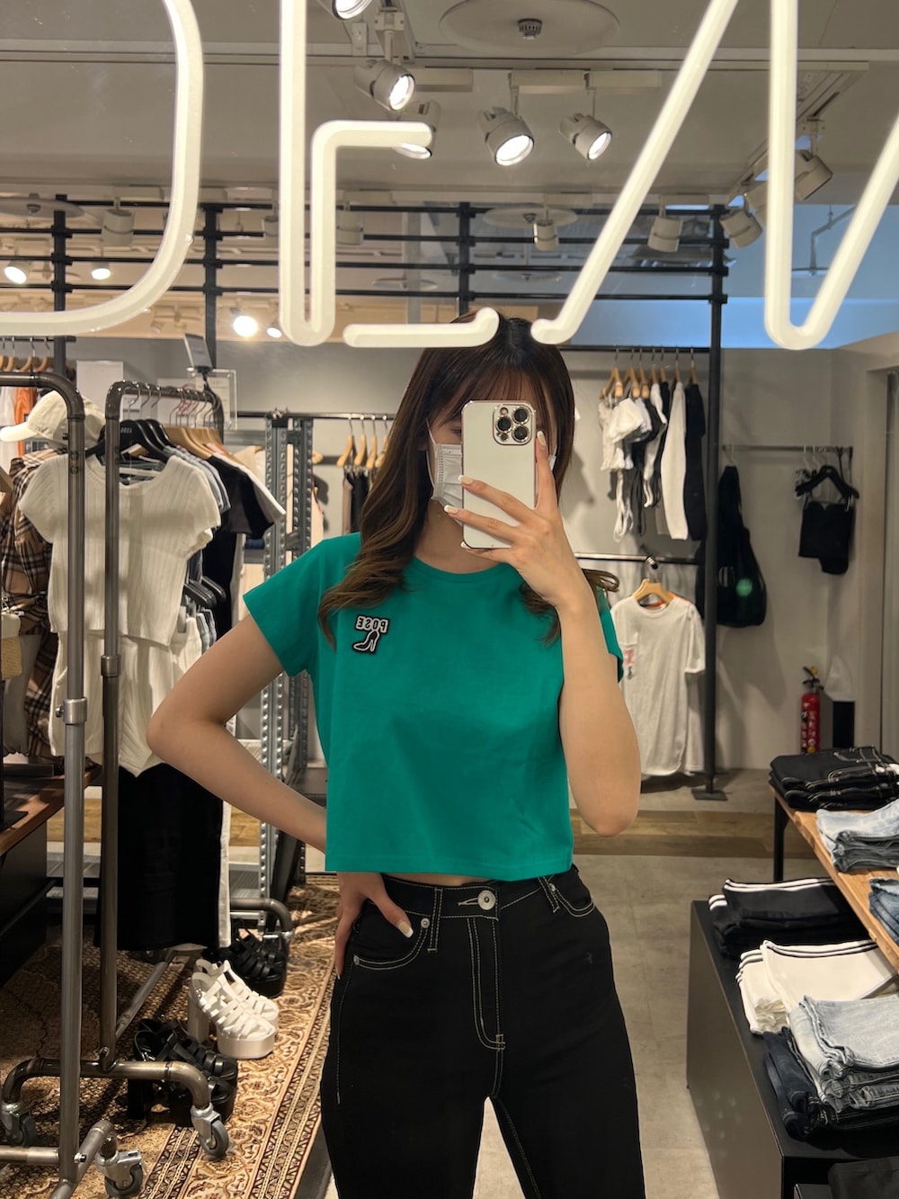 グリーン系のTシャツ/カットソー、ブラック系のデニムパンツ、ホワイト系のパンプスを着用したレディースの春コーディネートの2枚目の写真