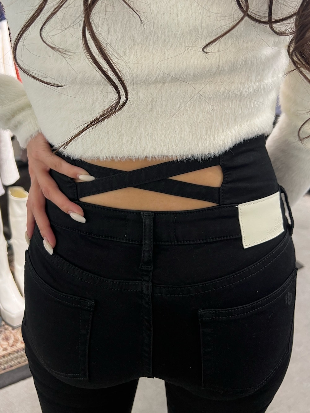 ホワイト系のニット/セーター、ブラック系のデニムパンツ、ホワイト系のパンプスを着用したレディースの冬コーディネートの4枚目の写真