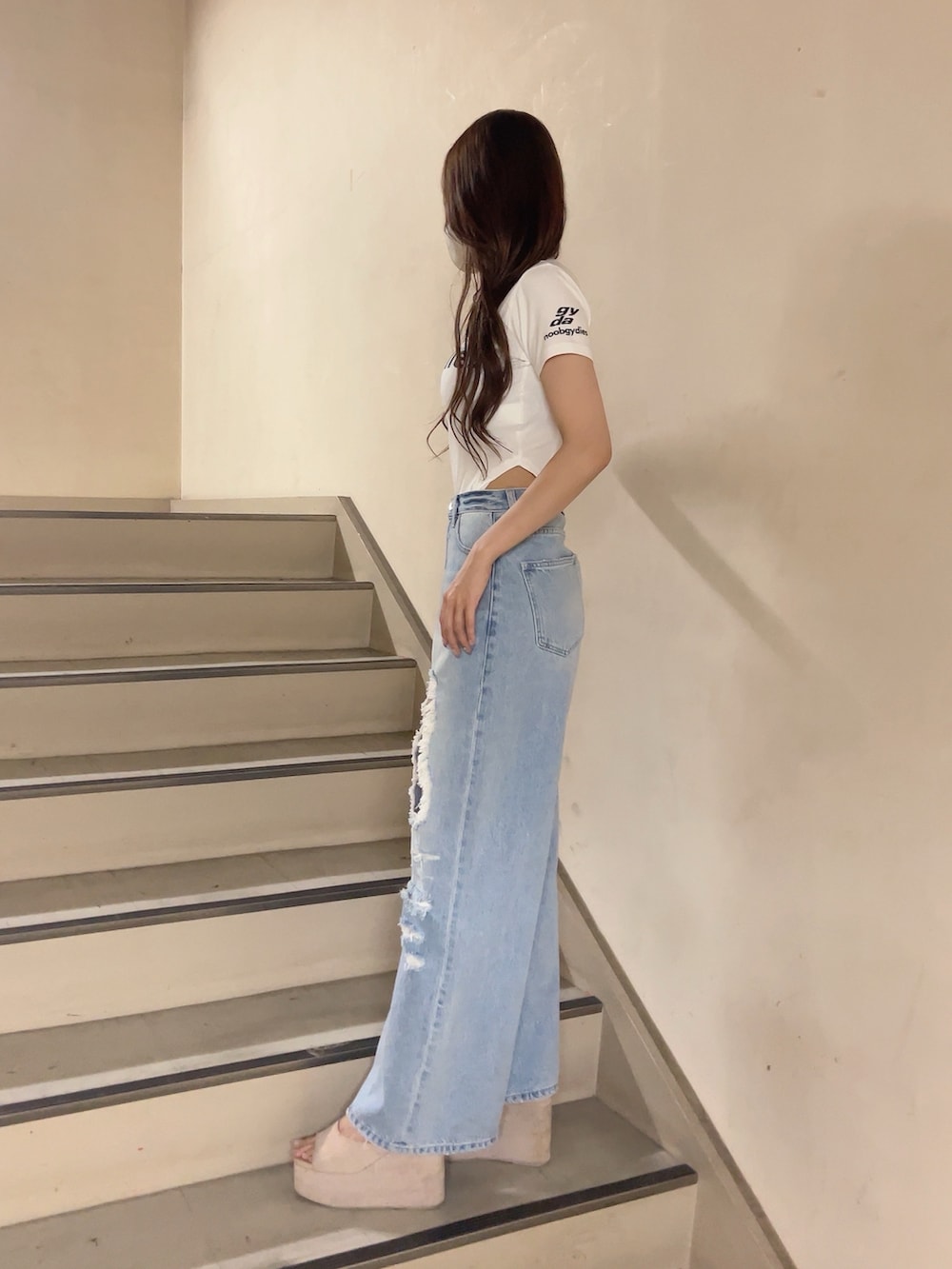 ホワイト系のTシャツ/カットソー、ブルー系のデニムパンツ、ホワイト系のサンダルを着用したレディースの夏コーディネートの2枚目の写真