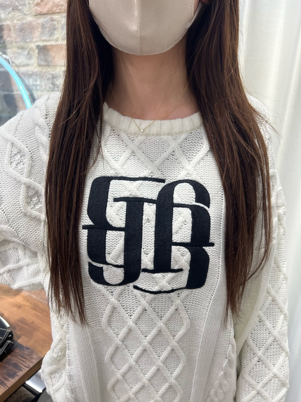 ホワイト系のニット/セーター、ブラック系のデニムパンツ、ブラック系のパンプスを着用したレディースの冬コーディネートの4枚目の写真