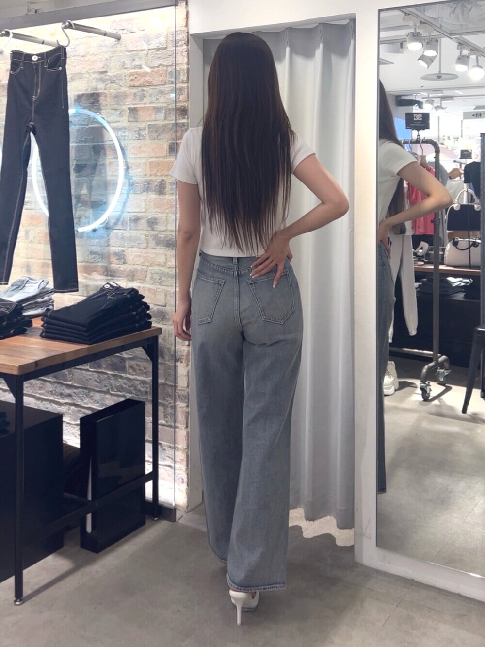 ホワイト系のTシャツ/カットソー、ブルー系のデニムパンツ、ホワイト系のパンプスを着用したレディースの春コーディネートの2枚目の写真