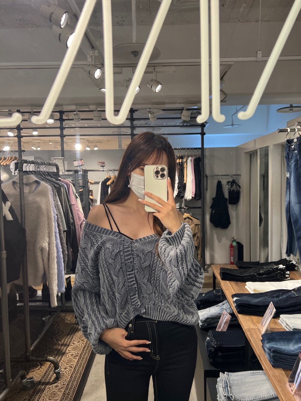 ブルー系のニット/セーター、ブラック系のキャミソール、ブラック系のデニムパンツを着用したレディースの秋コーディネートの3枚目の写真