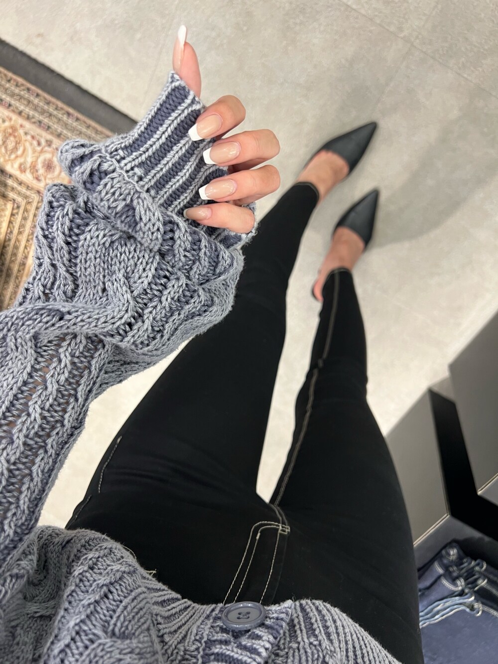 ブルー系のニット/セーター、ブラック系のキャミソール、ブラック系のデニムパンツを着用したレディースの秋コーディネートの5枚目の写真