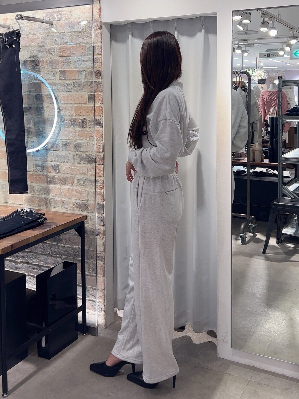 グレー系のスウェット、グレー系のスウェットパンツ、ブラック系のパンプスを着用したレディースの冬コーディネートの3枚目の写真