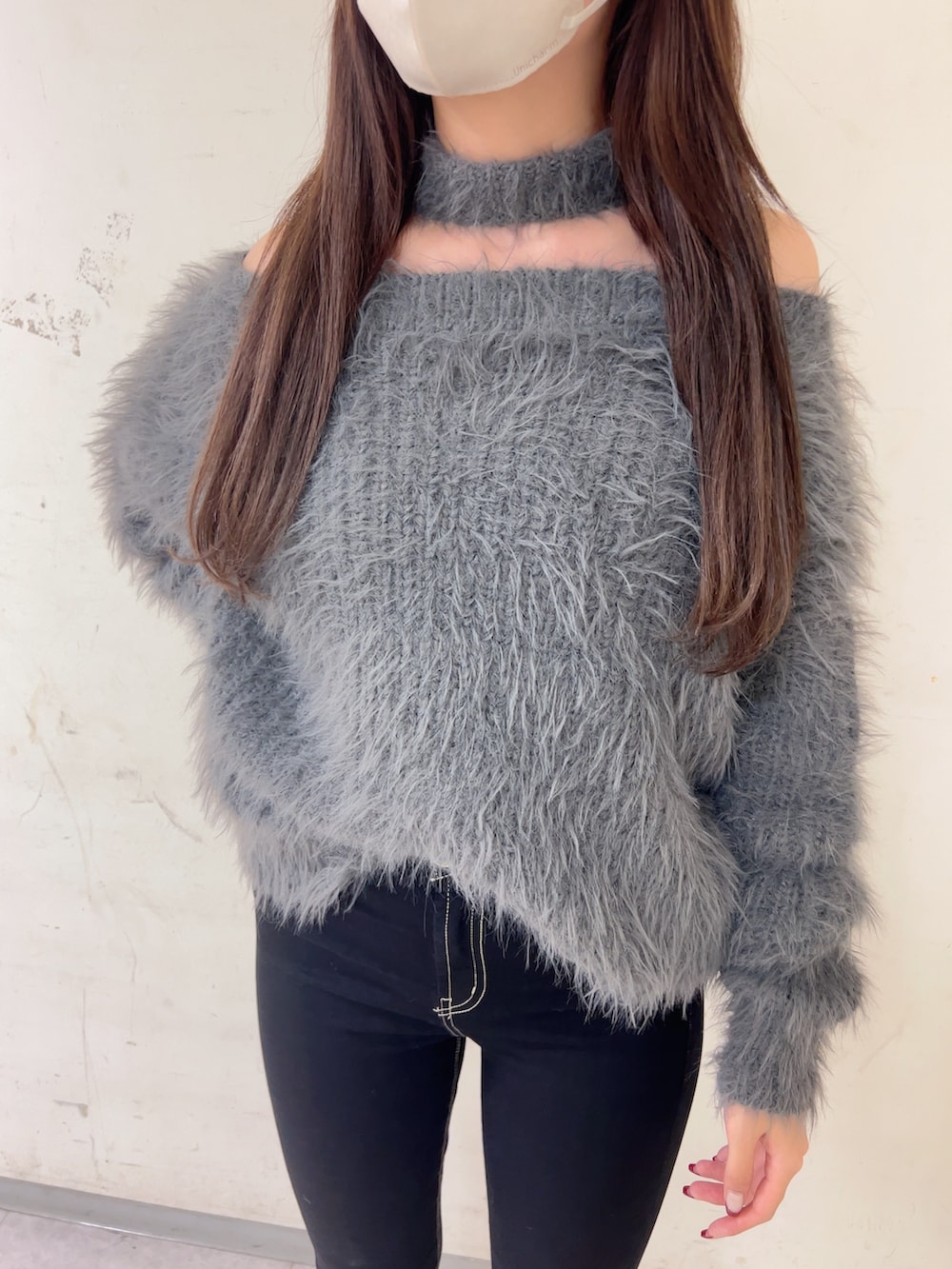 グレー系のニット/セーター、ブラック系のデニムパンツ、ホワイト系のパンプスを着用したレディースの秋コーディネートの4枚目の写真