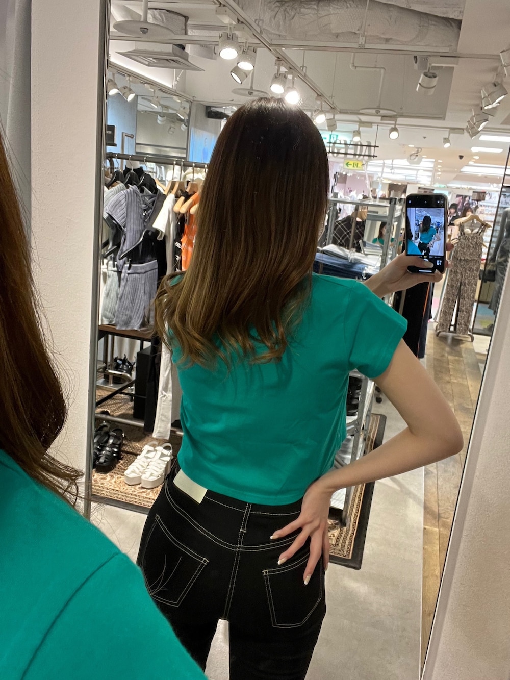 グリーン系のTシャツ/カットソー、ブラック系のデニムパンツ、ホワイト系のパンプスを着用したレディースの春コーディネートの4枚目の写真