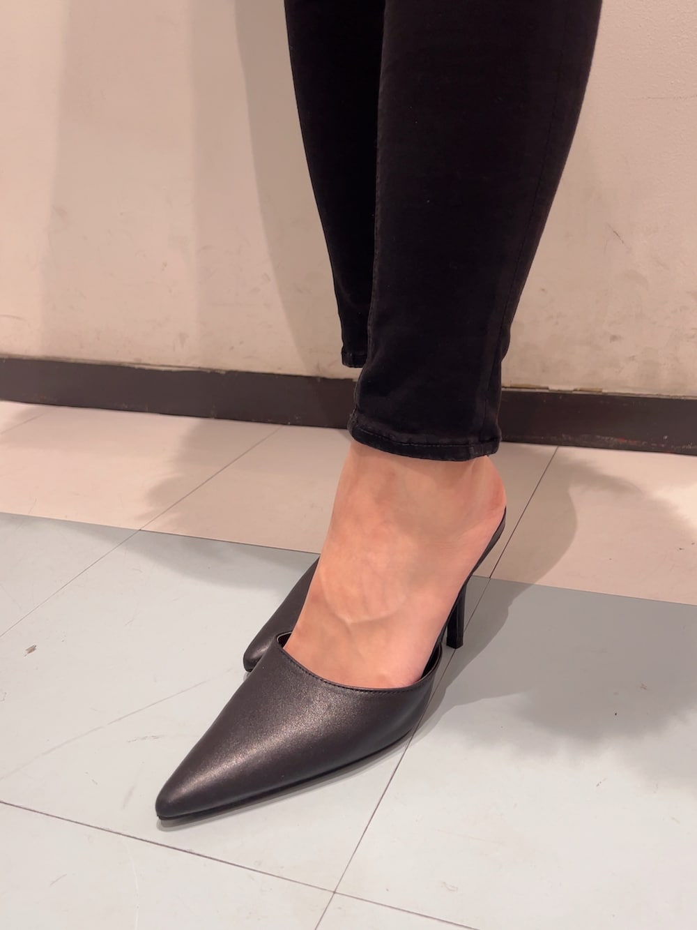 グレー系のカーディガン/ボレロ、ホワイト系のキャミソール、ブラック系のデニムパンツを着用したレディースの秋コーディネートの7枚目の写真