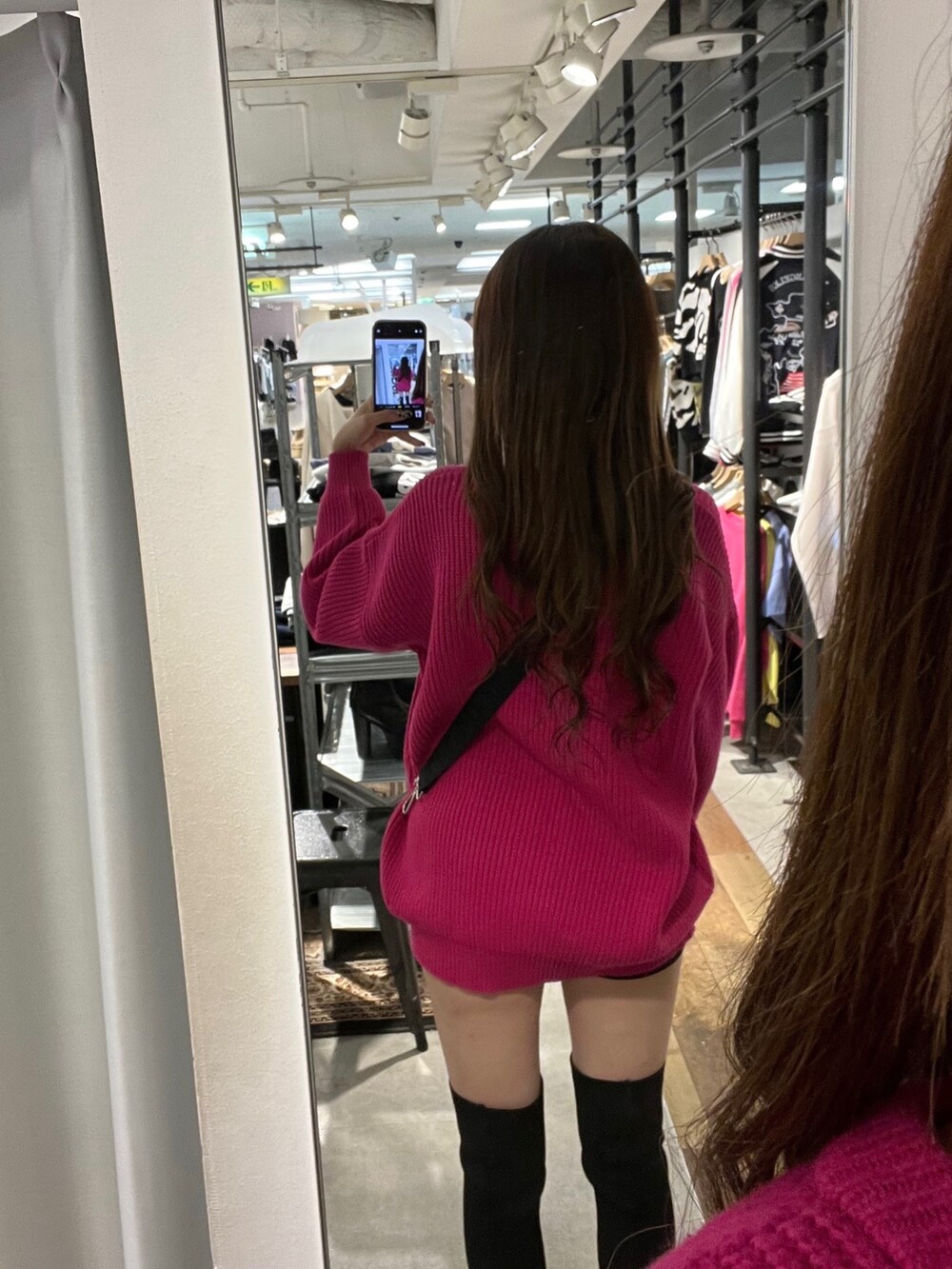 ピンク系のニット/セーター、ブラック系のデニムパンツ、ブラック系のブーツを着用したレディースの秋コーディネートの3枚目の写真