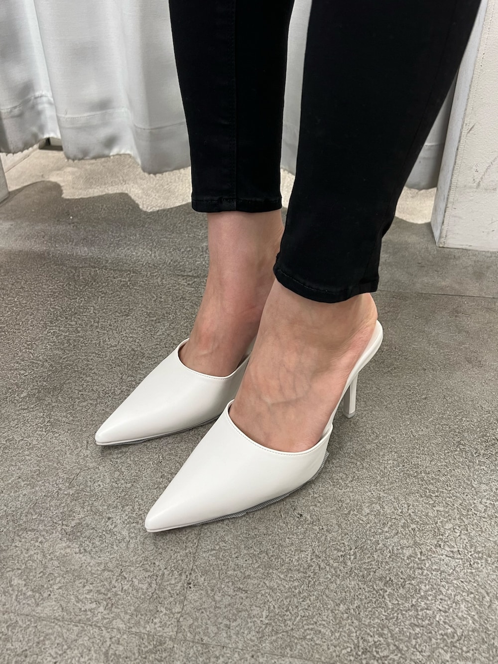 ブラック系のキャミソール、ブラック系のデニムパンツ、ホワイト系のパンプスを着用したレディースの春コーディネートの6枚目の写真