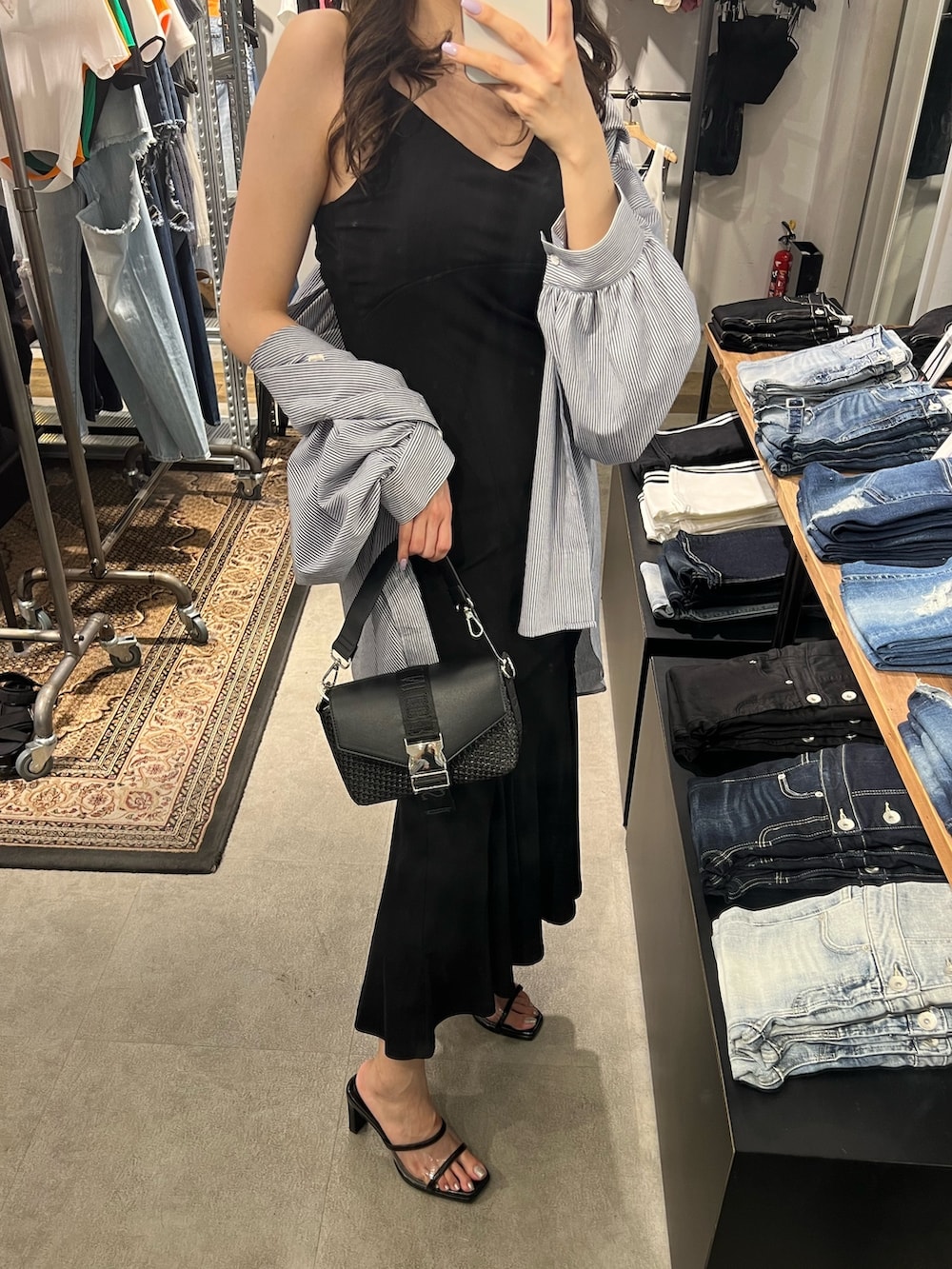 ブラック系のワンピース、ブルー系のシャツ/ブラウス、ブラック系のハンドバッグを着用したレディースの春コーディネートの3枚目の写真