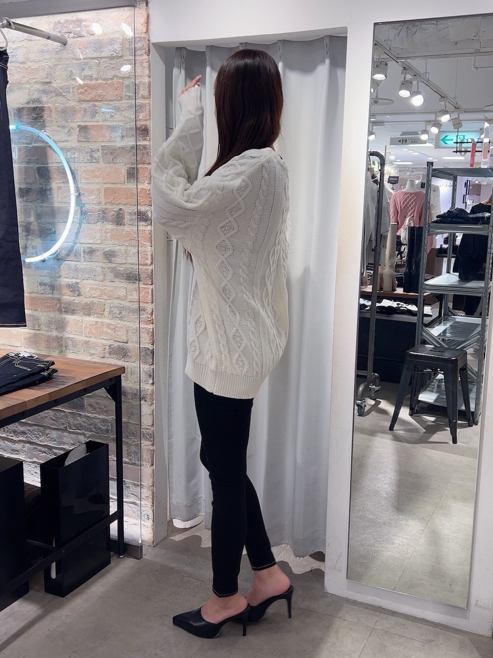 ホワイト系のニット/セーター、ブラック系のデニムパンツ、ブラック系のパンプスを着用したレディースの冬コーディネートの3枚目の写真