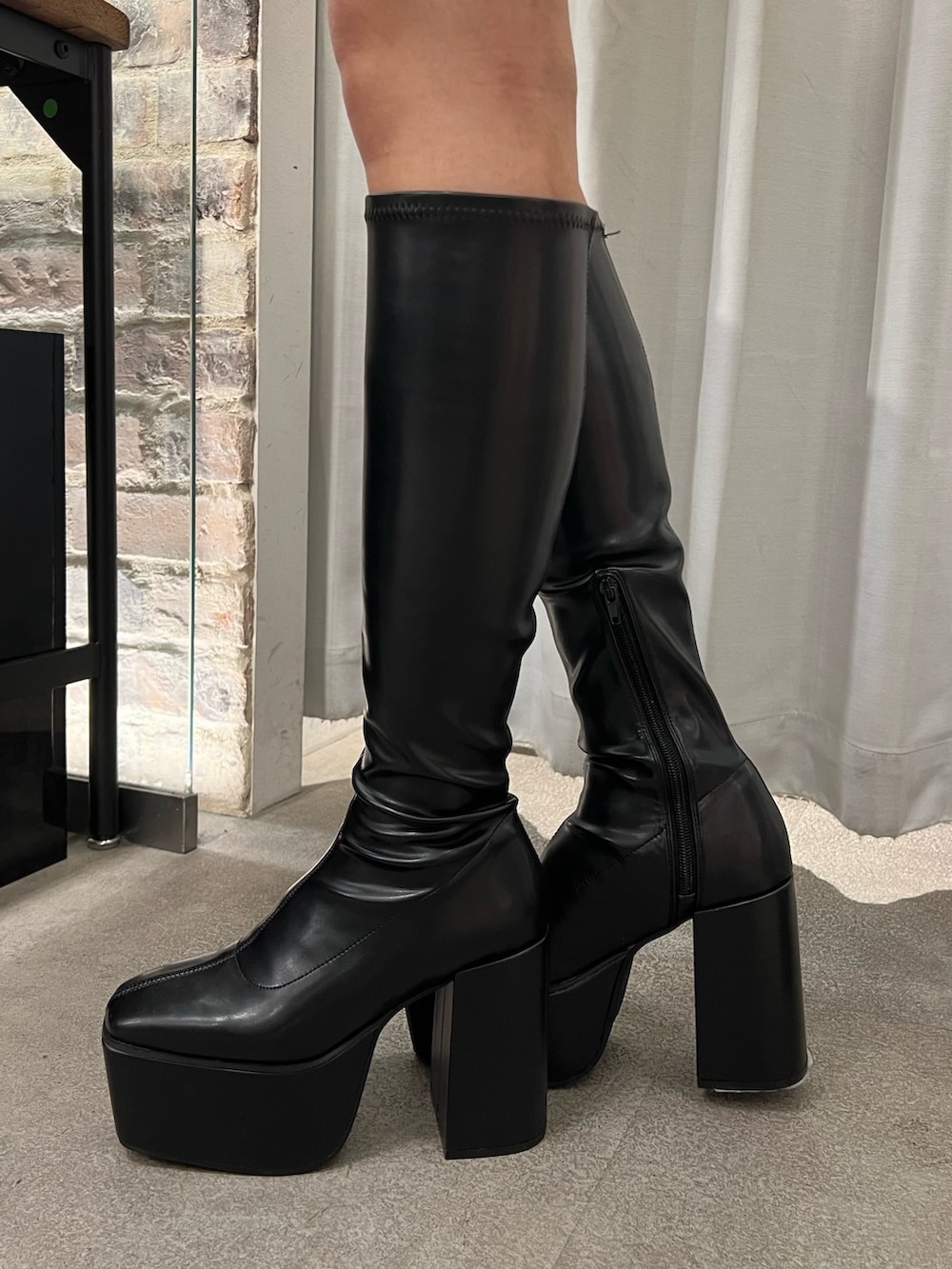 オレンジ系のニット/セーター、ブラック系のブーツを着用したレディースの冬コーディネートの4枚目の写真