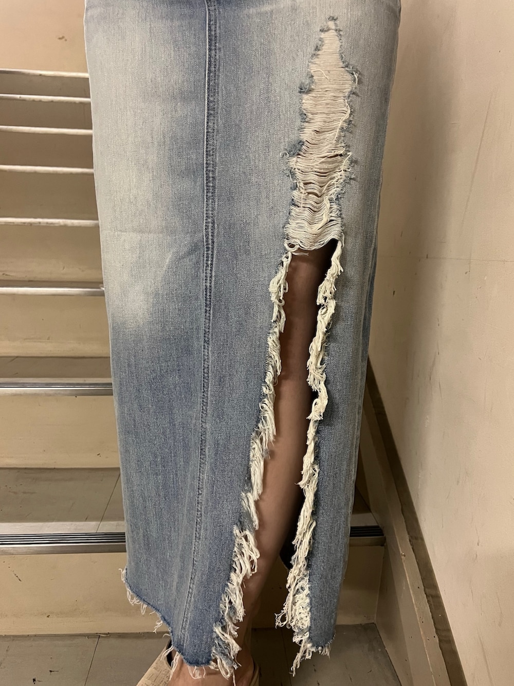 ホワイト系のニット/セーター、ブルー系のデニムスカート、ホワイト系のサンダルを着用したレディースの春コーディネートの6枚目の写真