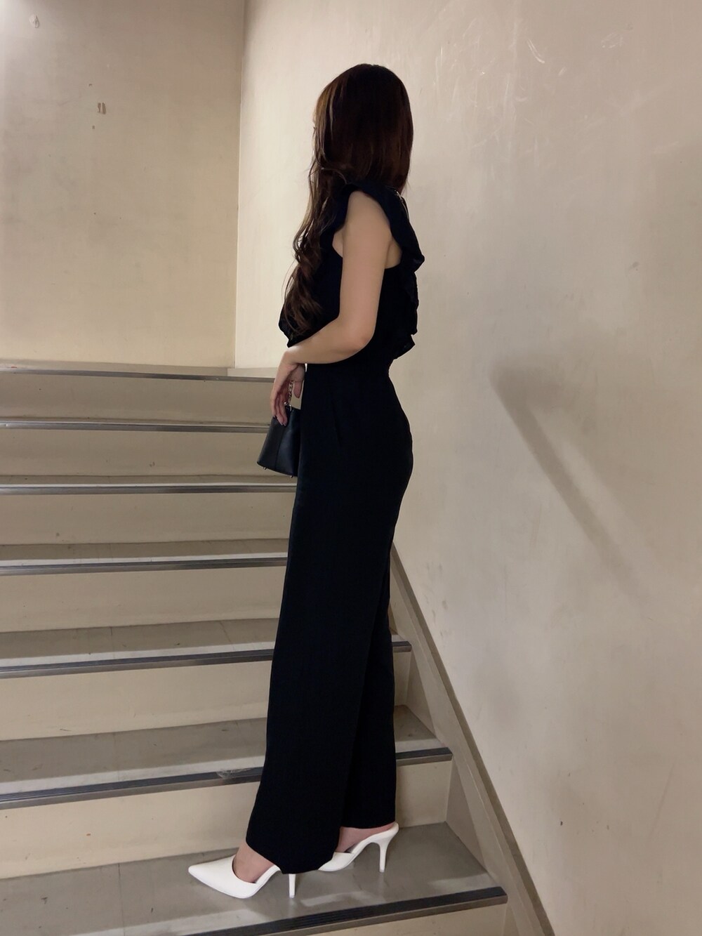 ブラック系のつなぎ/オールインワン、ホワイト系のパンプス、ブラック系のショルダーバッグを着用したレディースの夏コーディネートの3枚目の写真