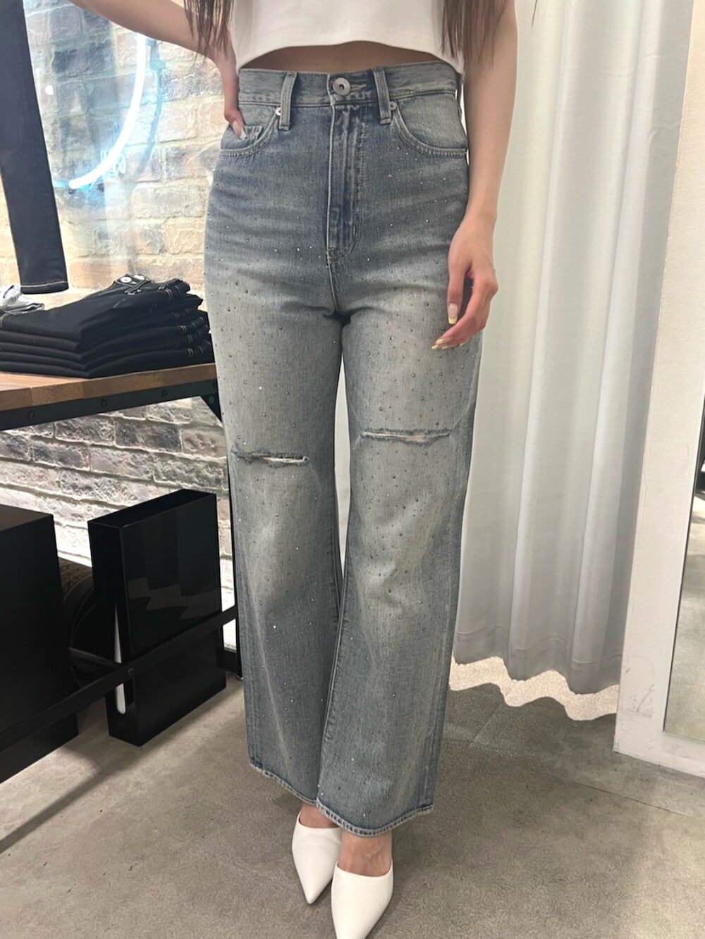 ホワイト系のTシャツ/カットソー、ブルー系のデニムパンツ、ホワイト系のパンプスを着用したレディースの春コーディネートの5枚目の写真