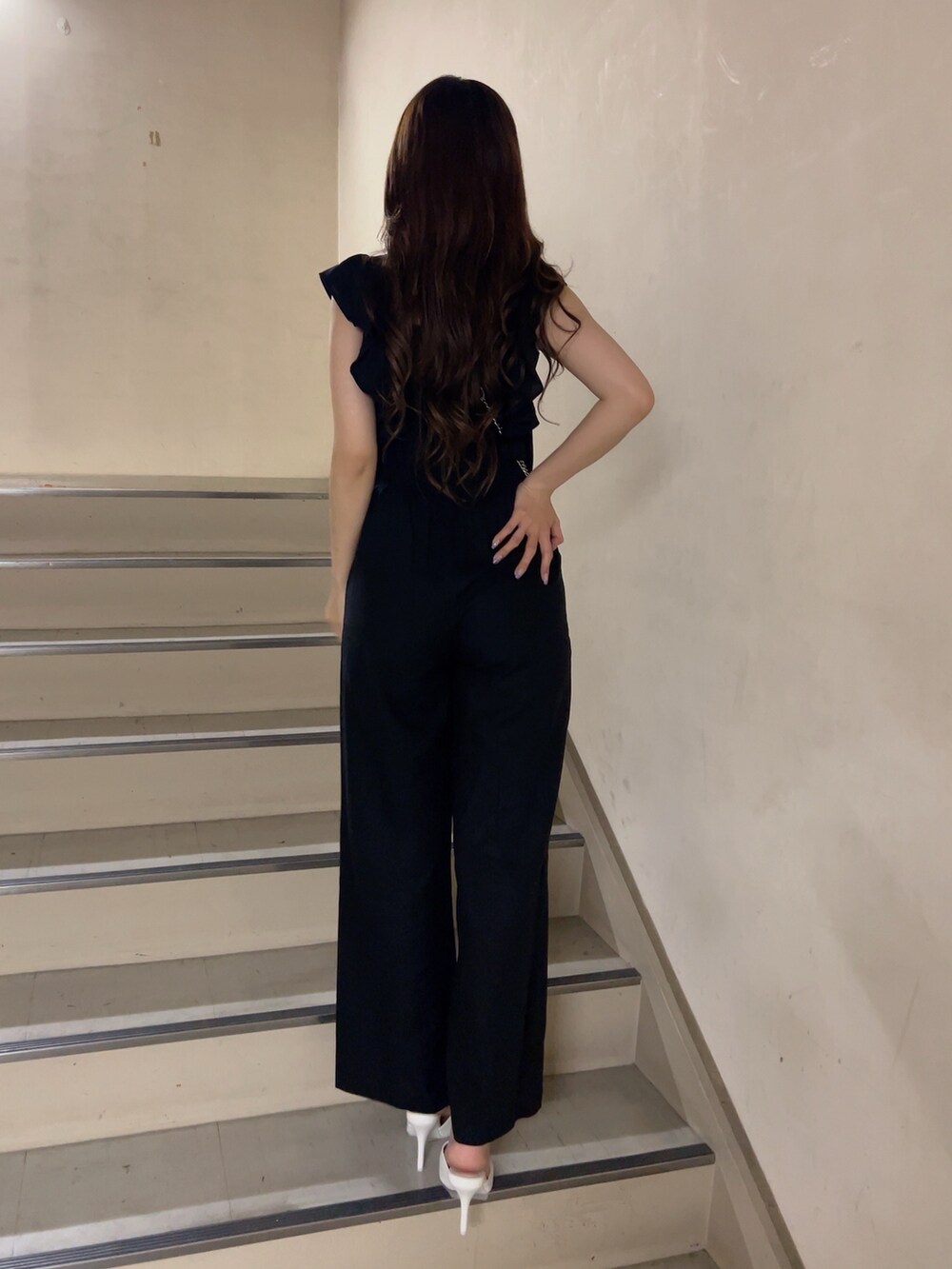 ブラック系のつなぎ/オールインワン、ホワイト系のパンプス、ブラック系のショルダーバッグを着用したレディースの夏コーディネートの2枚目の写真