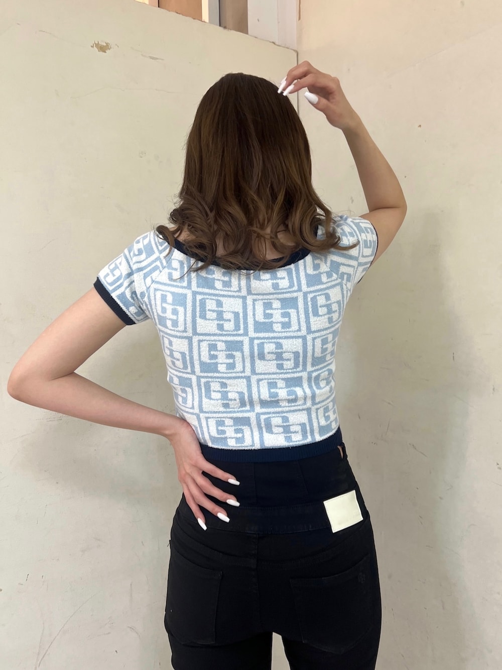 ブルー系のニット/セーター、ホワイト系のバックパック/リュック、ブラック系のパンプスを着用したレディースの春コーディネートの4枚目の写真