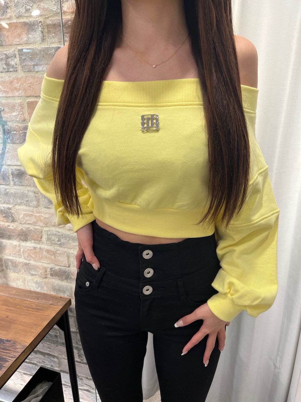 イエロー系のスウェット、ブラック系のデニムパンツ、ブラック系のパンプスを着用したレディースの冬コーディネートの4枚目の写真