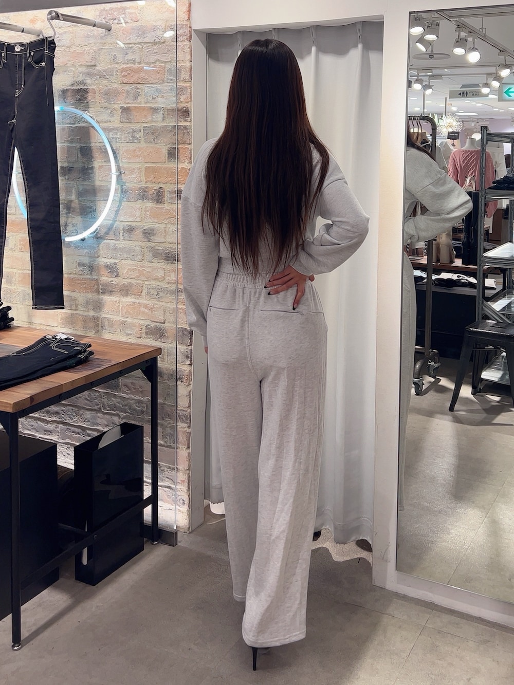 グレー系のスウェット、グレー系のスウェットパンツ、ブラック系のパンプスを着用したレディースの冬コーディネートの2枚目の写真