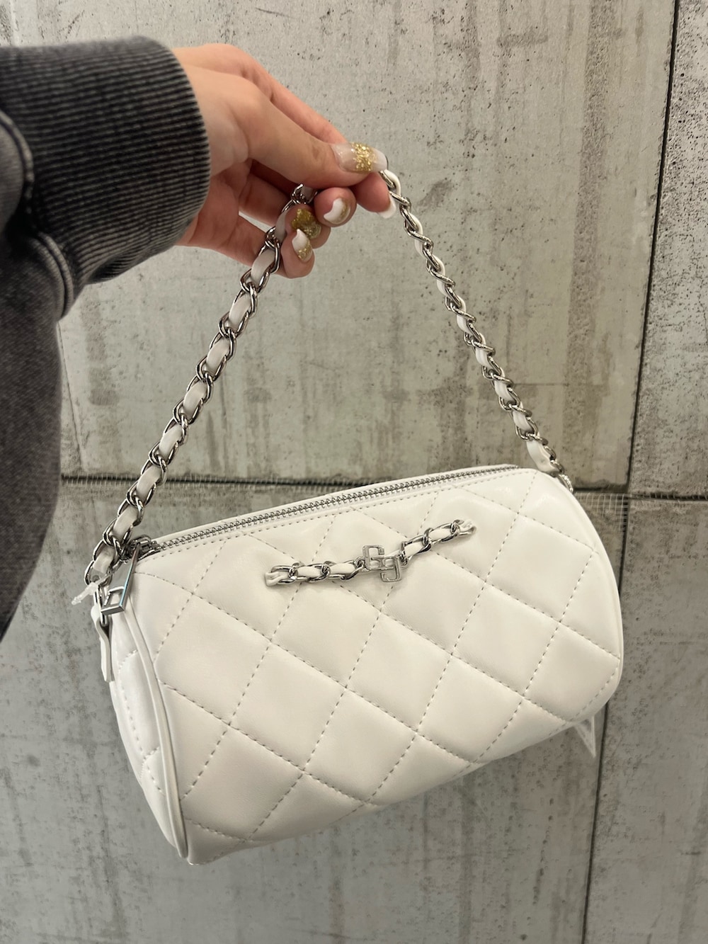 ホワイト系のニット/セーター、ブルー系のデニムパンツ、ホワイト系のハンドバッグを着用したレディースの冬コーディネートの6枚目の写真