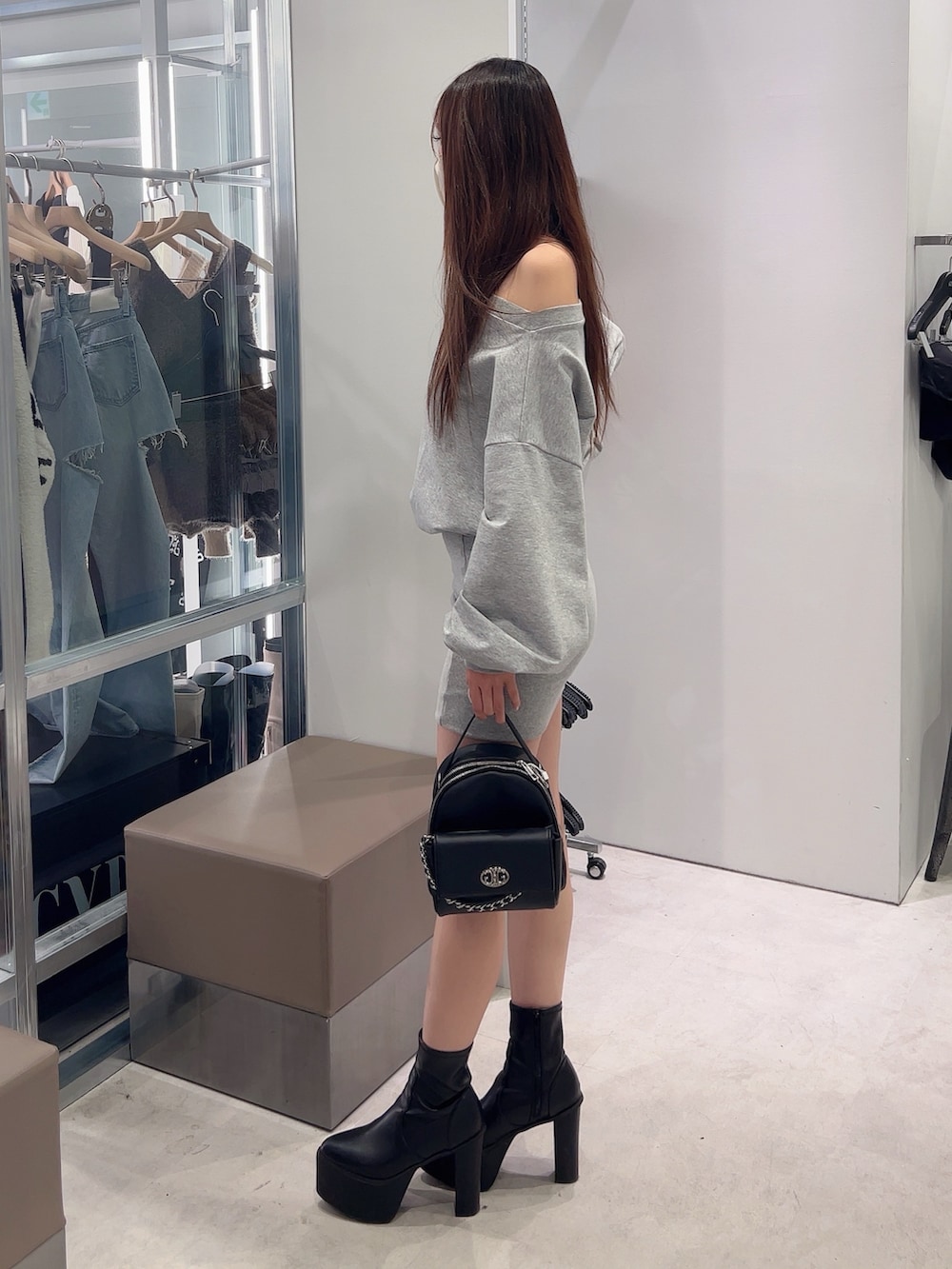 グレー系のワンピース、ブラック系のバックパック/リュック、ブラック系のブーツを着用したレディースの秋コーディネートの3枚目の写真