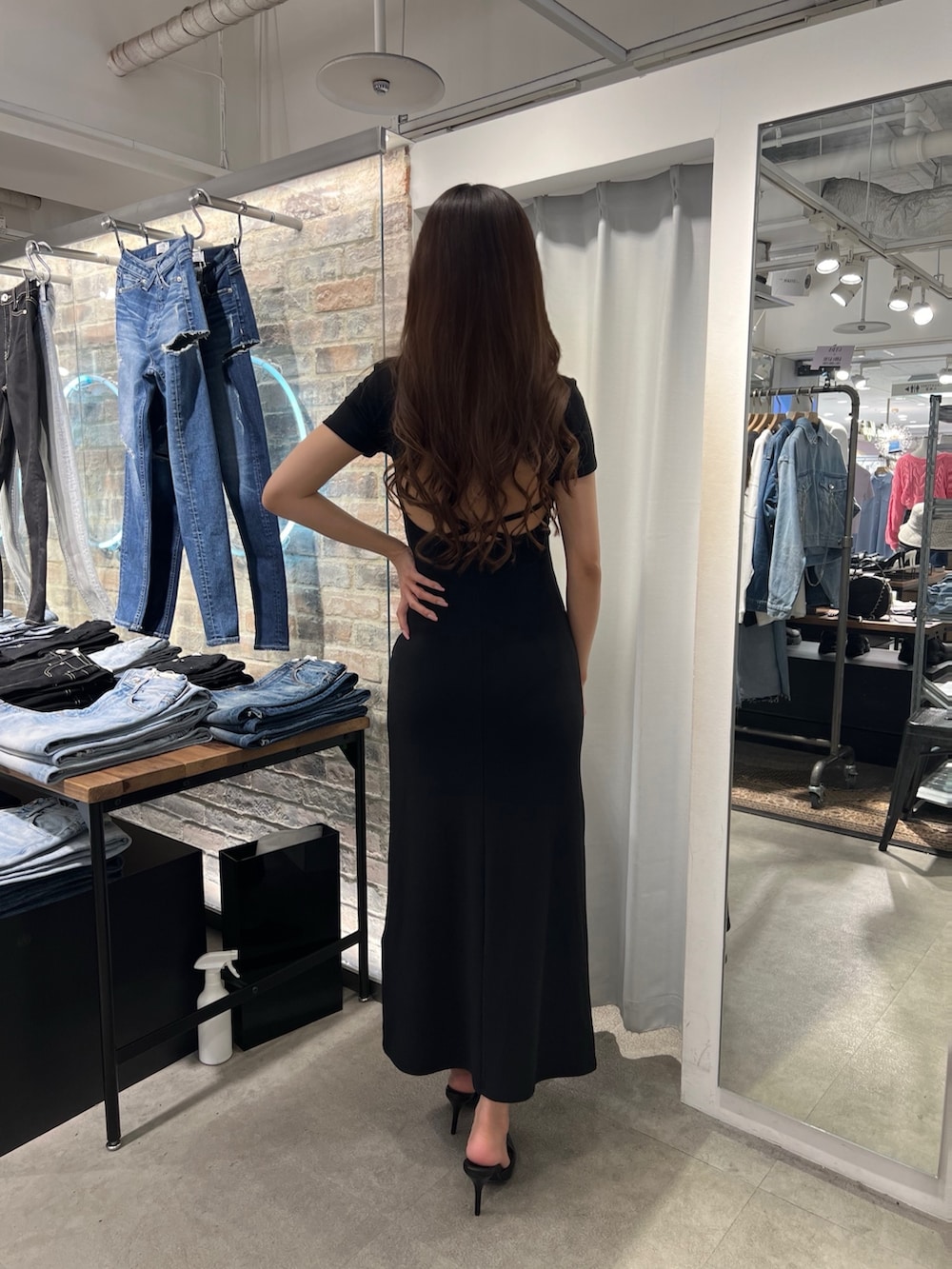 ブラック系のワンピース、ブルー系のデニムジャケット、ブラック系のパンプスを着用したレディースの春コーディネートの2枚目の写真