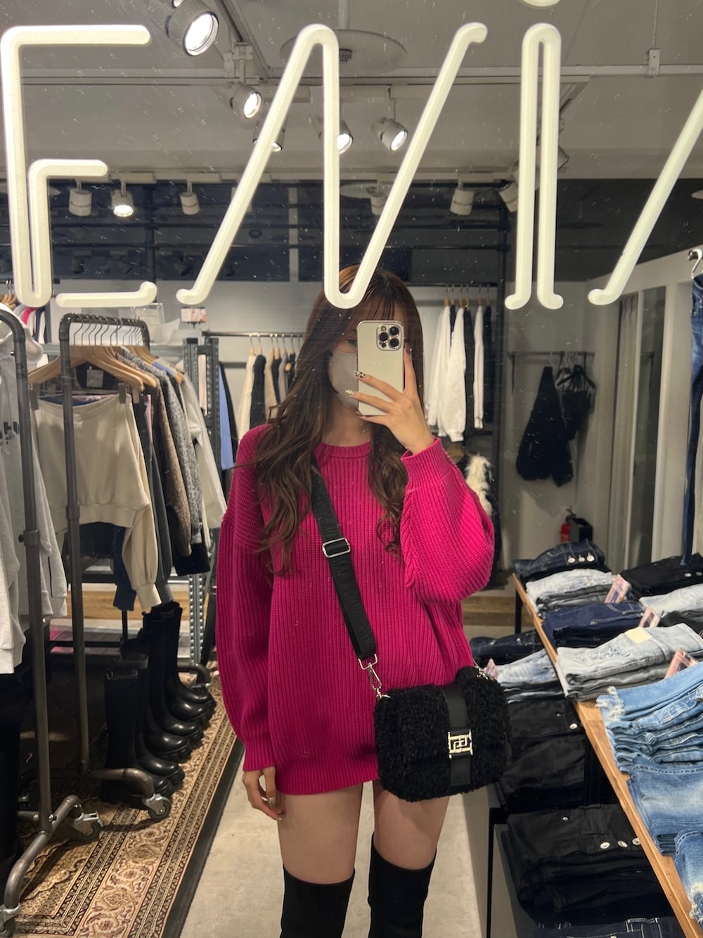 ピンク系のニット/セーター、ブラック系のデニムパンツ、ブラック系のブーツを着用したレディースの秋コーディネートの2枚目の写真