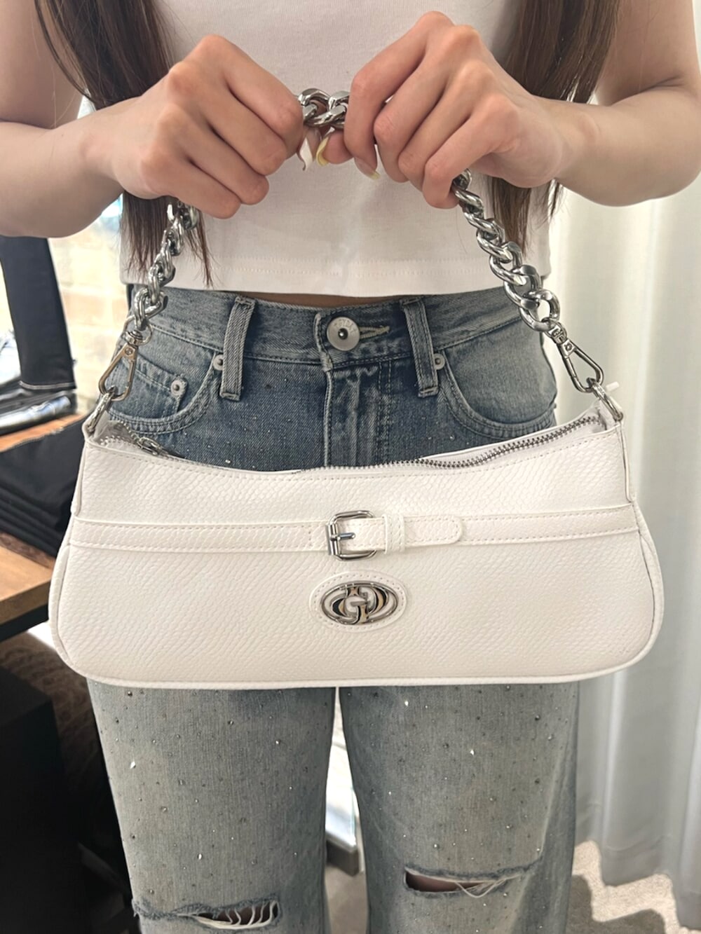 ホワイト系のTシャツ/カットソー、ブルー系のデニムパンツ、ホワイト系のパンプスを着用したレディースの春コーディネートの7枚目の写真