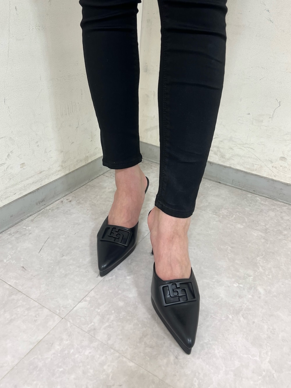 ブルー系のニット/セーター、ホワイト系のバックパック/リュック、ブラック系のパンプスを着用したレディースの春コーディネートの5枚目の写真