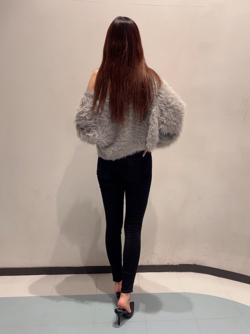 グレー系のカーディガン/ボレロ、ホワイト系のキャミソール、ブラック系のデニムパンツを着用したレディースの秋コーディネートの2枚目の写真