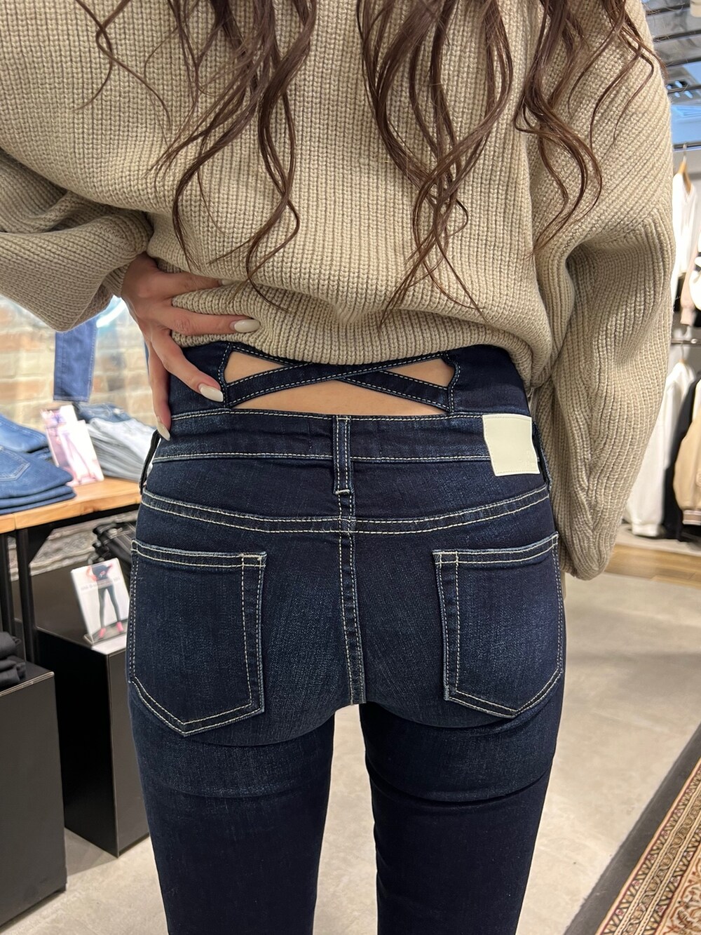 ベージュ系のニット/セーター、ブルー系のデニムパンツ、ブラック系のパンプスを着用したレディースの冬コーディネートの5枚目の写真
