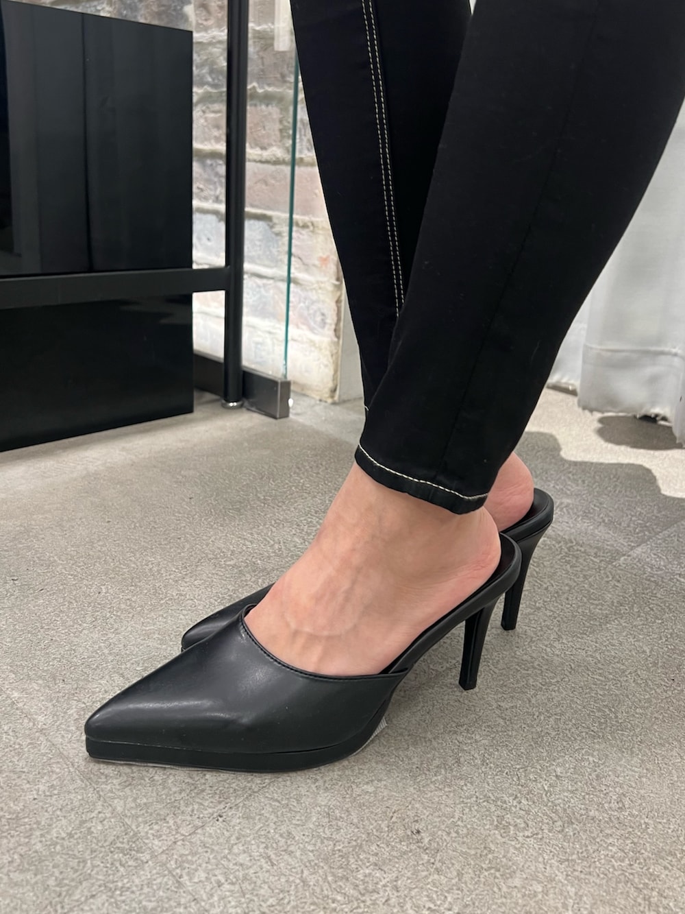 ホワイト系のニット/セーター、ブラック系のデニムパンツ、ブラック系のパンプスを着用したレディースの冬コーディネートの6枚目の写真