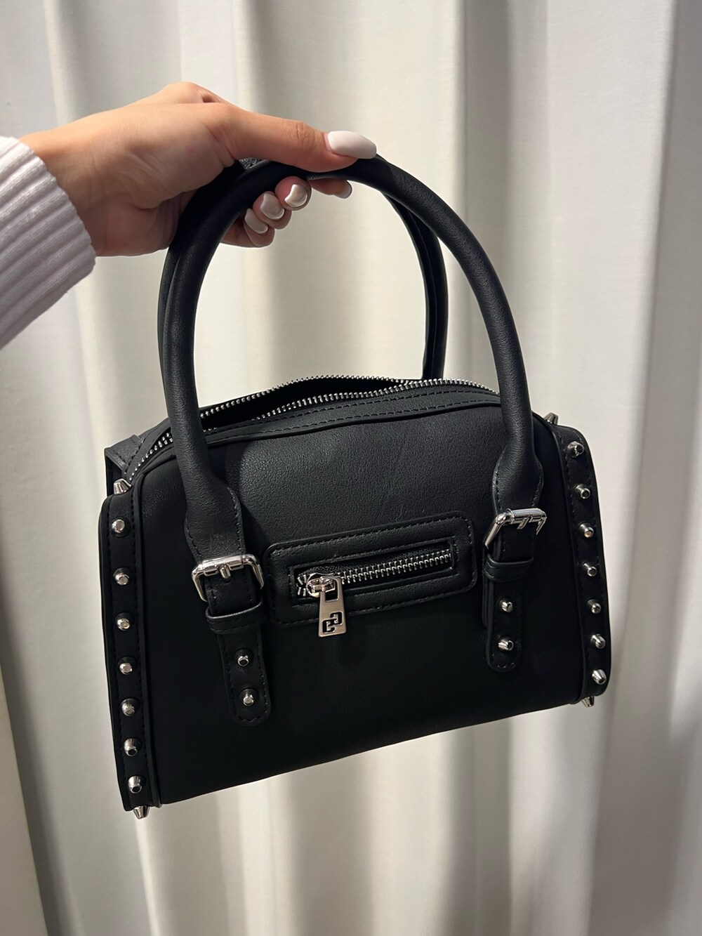 ホワイト系のムートンコート、ホワイト系のニット/セーター、ブラック系のスカートを着用したレディースの秋コーディネートの6枚目の写真