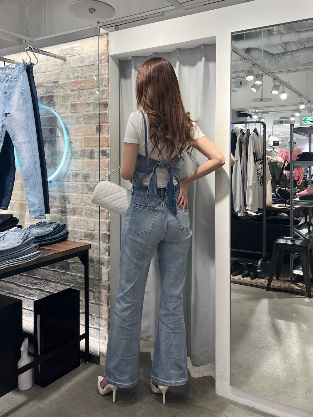 ブルー系のサロペット/オーバーオール、ホワイト系のTシャツ/カットソー、ホワイト系のパンプスを着用したレディースの冬コーディネートの2枚目の写真