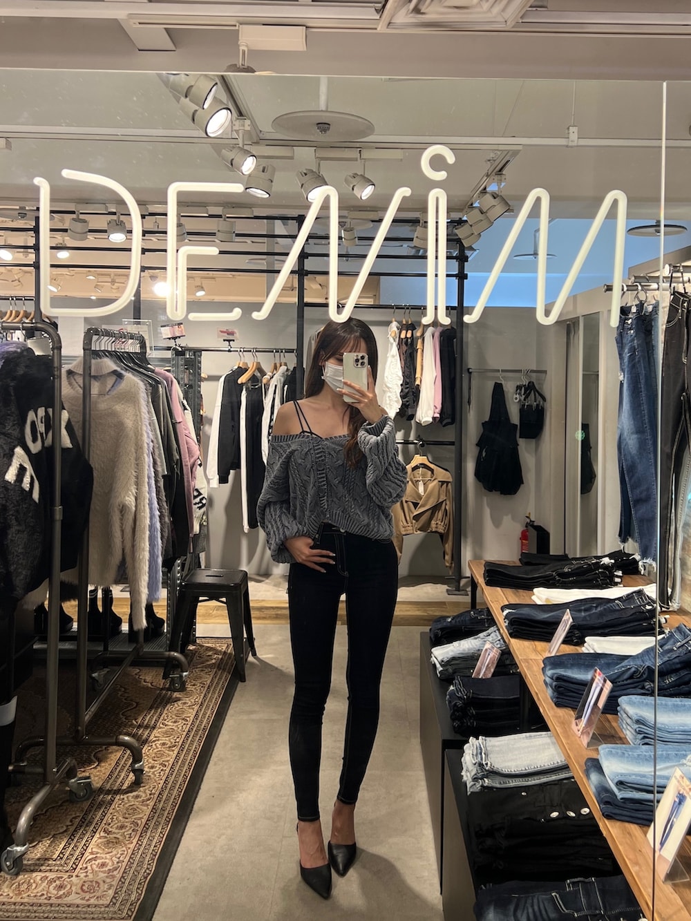 ブルー系のニット/セーター、ブラック系のキャミソール、ブラック系のデニムパンツを着用したレディースの秋コーディネートの2枚目の写真