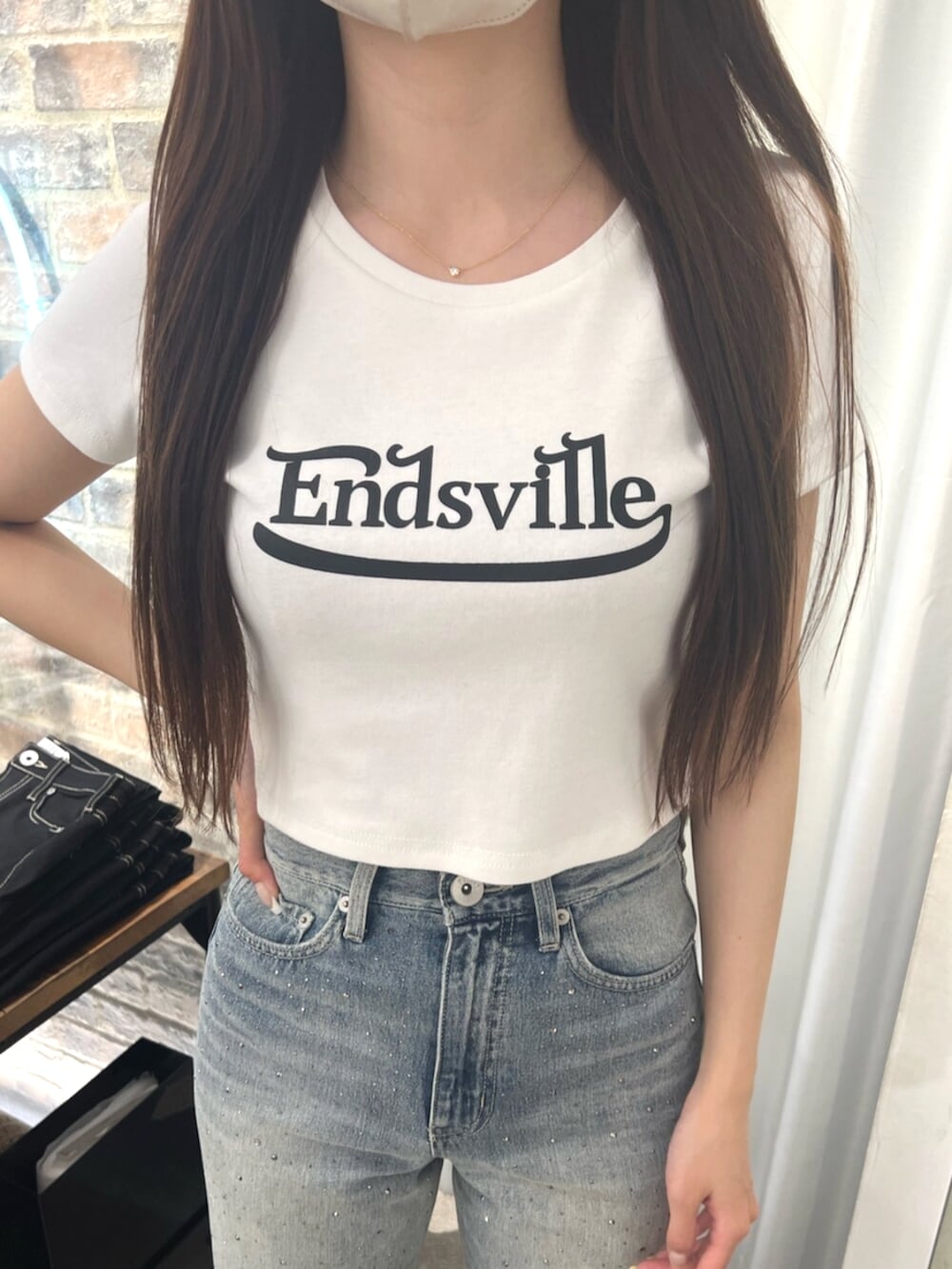 ホワイト系のTシャツ/カットソー、ブルー系のデニムパンツ、ホワイト系のパンプスを着用したレディースの春コーディネートの4枚目の写真