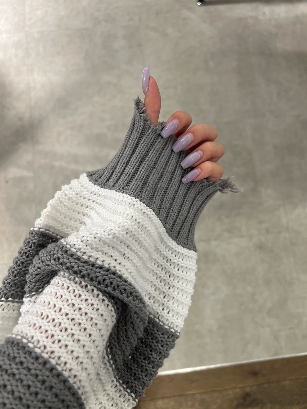 ブラック系のタンクトップ、グレー系のカーディガン/ボレロ、ブラック系のデニムパンツを着用したレディースの夏コーディネートの4枚目の写真