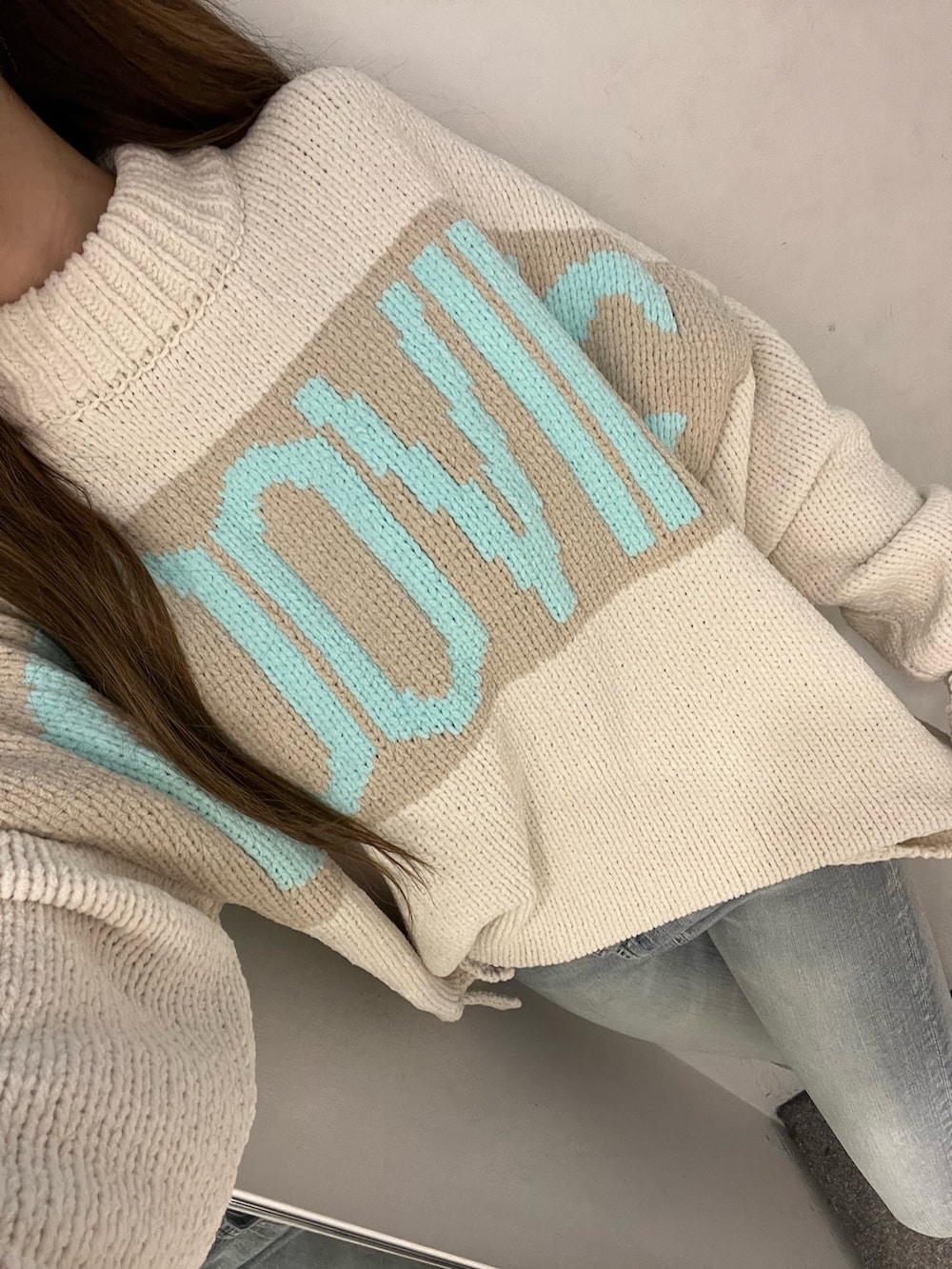 ホワイト系のニット/セーター、ブルー系のデニムパンツ、ホワイト系のハンドバッグを着用したレディースの冬コーディネートの3枚目の写真