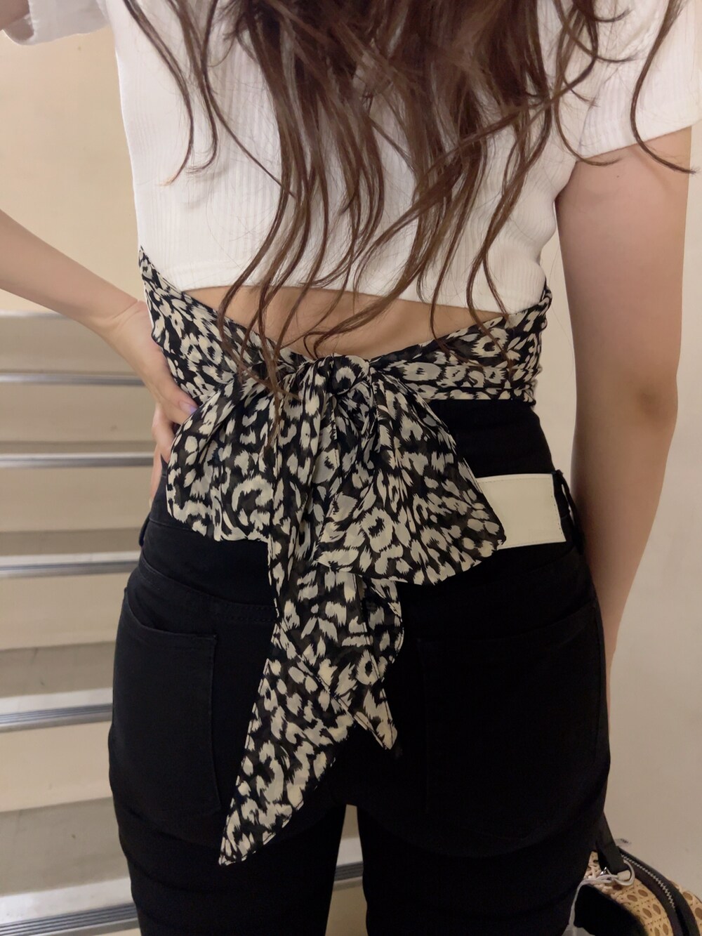 ホワイト系のTシャツ/カットソー、ブラック系のデニムパンツ、ブラック系のサンダルを着用したレディースの夏コーディネートの4枚目の写真