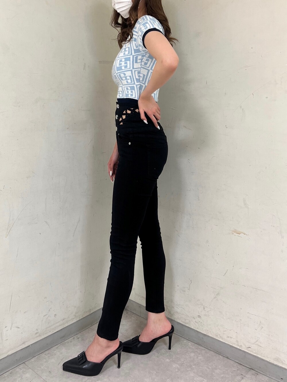 ブルー系のニット/セーター、ホワイト系のバックパック/リュック、ブラック系のパンプスを着用したレディースの春コーディネートの2枚目の写真