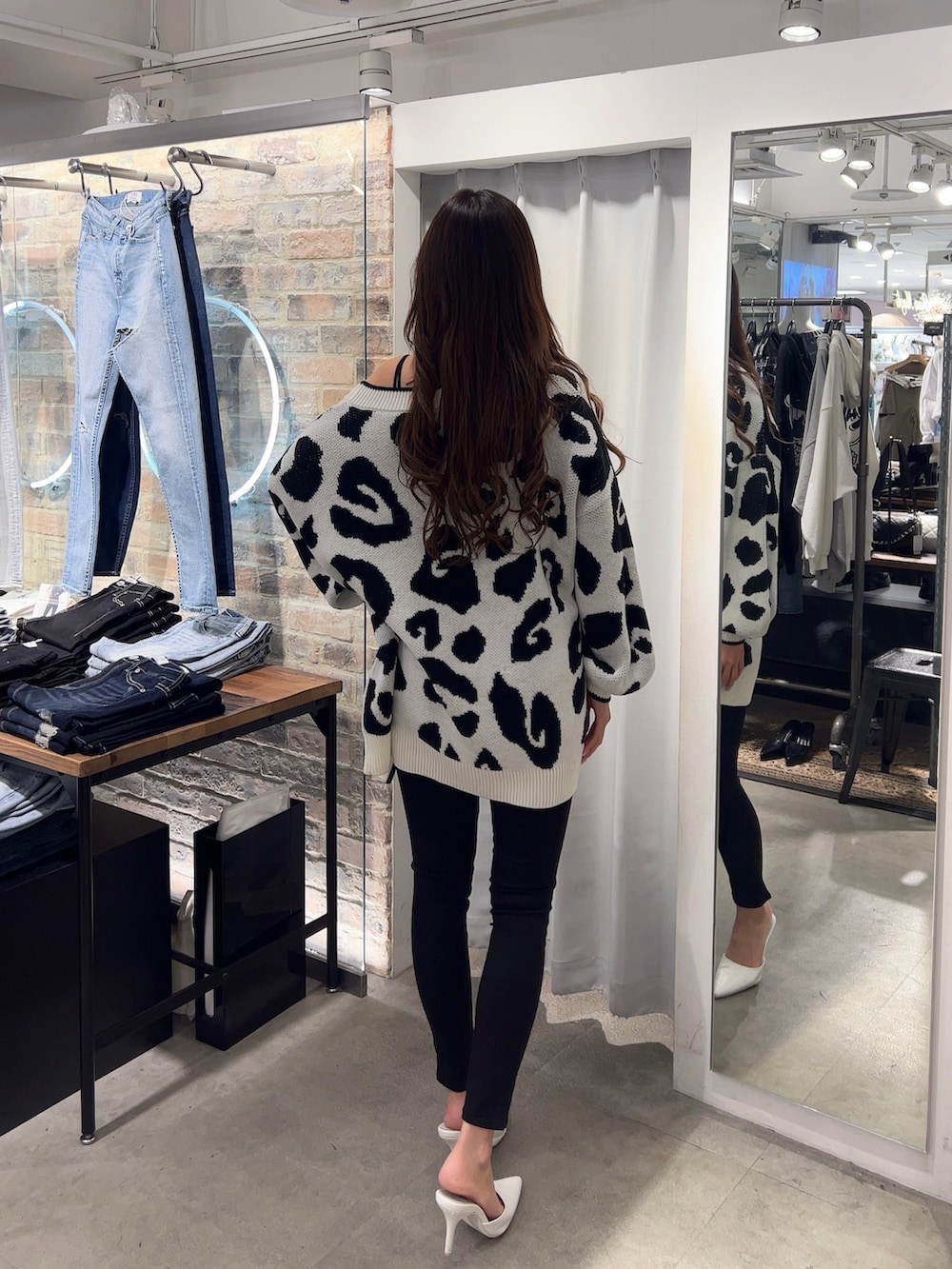 ブラック系のキャミソール、ブラック系のデニムパンツ、ホワイト系のパンプスを着用したレディースの春コーディネートの3枚目の写真