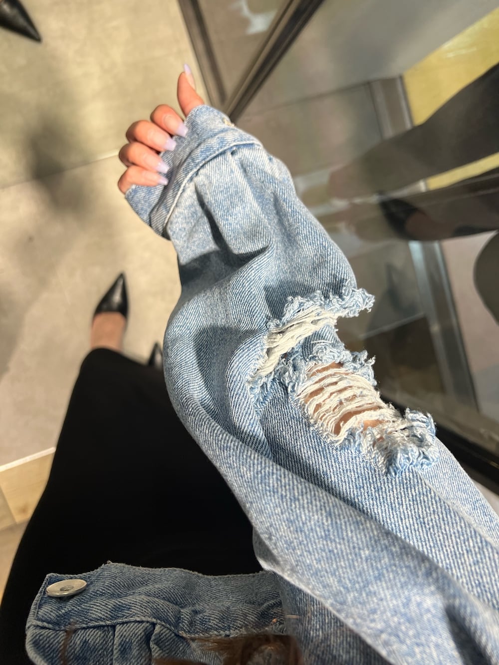 ブラック系のワンピース、ブルー系のデニムジャケット、ブラック系のパンプスを着用したレディースの春コーディネートの5枚目の写真